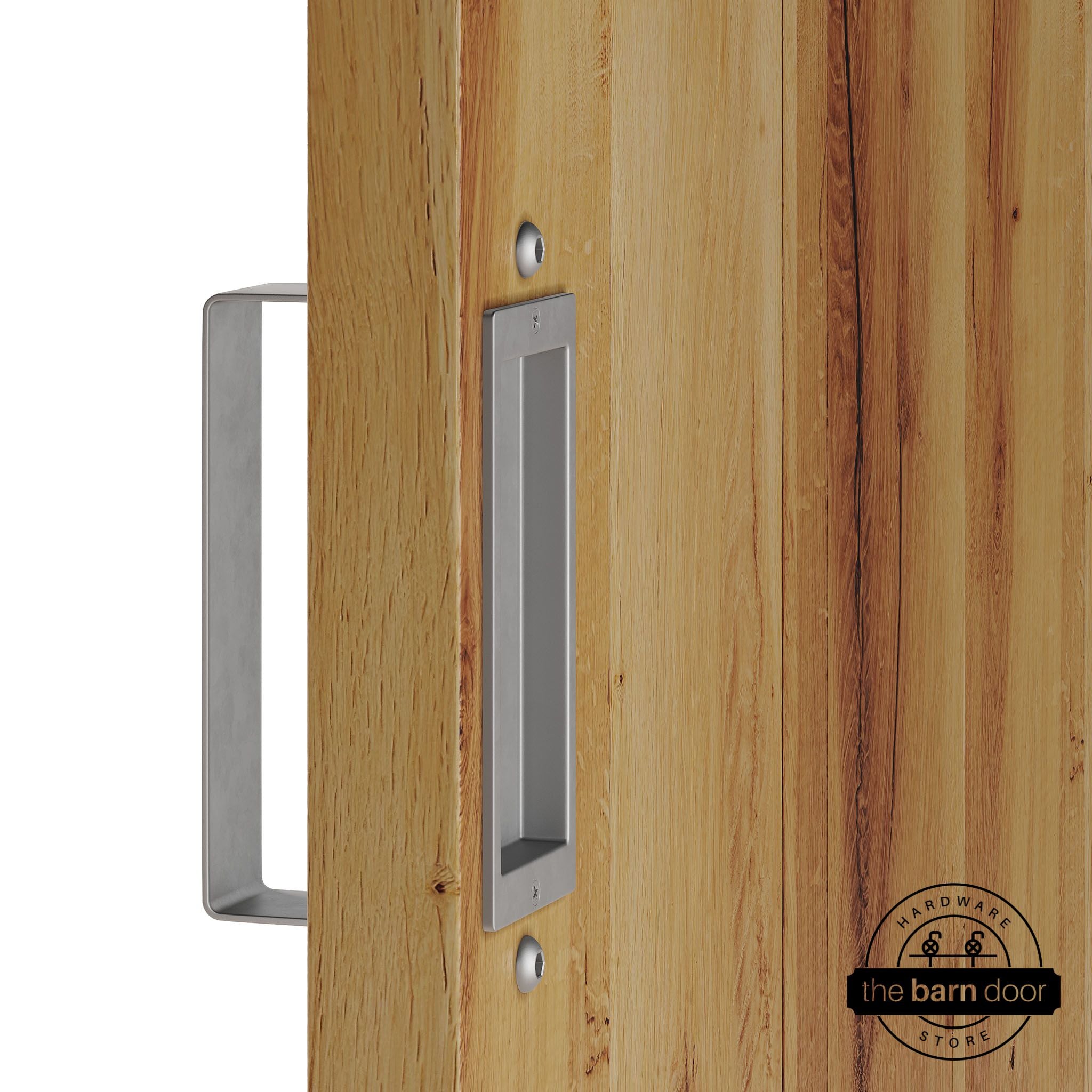 Raw steel barn door pull handle set installed on a natural wood sliding door, featuring a rectangular U-shaped pull handle on the front face and a flush recessed pull plate on the reverse side, shown in a raw steel finish.