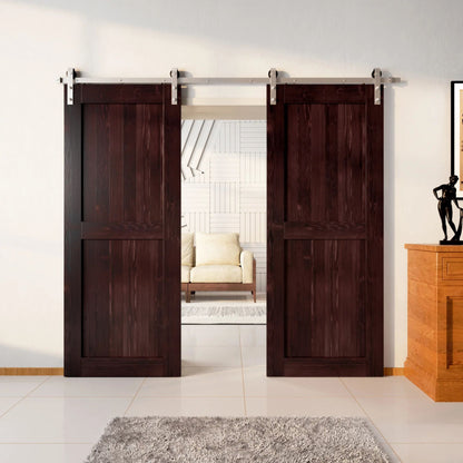 Two wood double barn doors with a two-panel vertical plank design in a rich, dark Red Mahogany stain, installed with brushed nickel sliding hardware, partially revealing a living room area.