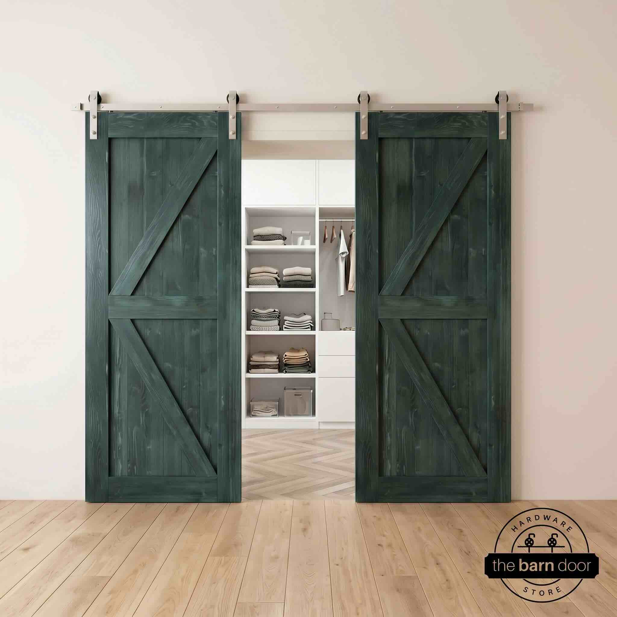 Two wood double barn doors with a two-panel vertical plank design in a royal pine stain, installed with brushed nickel sliding hardware, partially revealing a living room area.