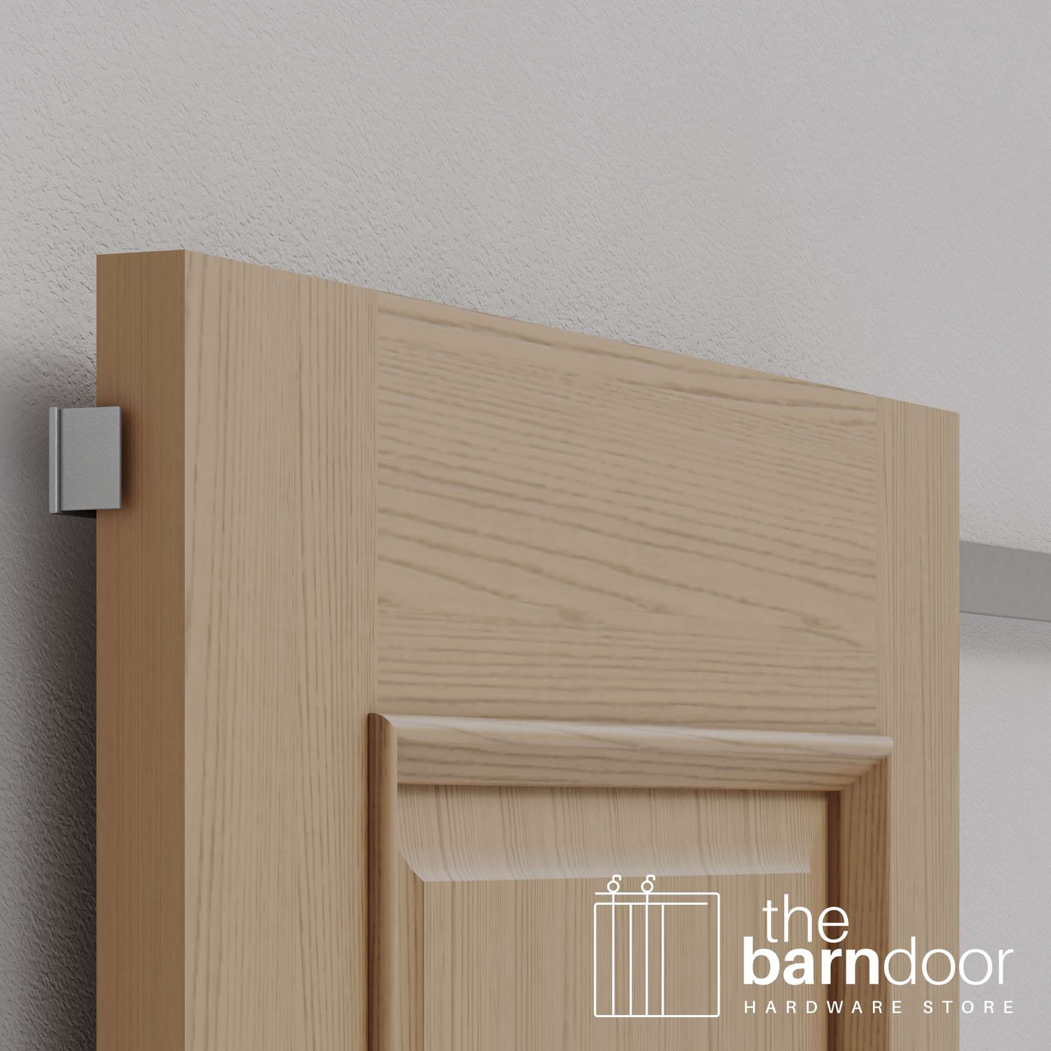 A detail shot of the small, silver wall-mounted guide that ensures a smooth glide, the secret to our invisible barn door hardware.