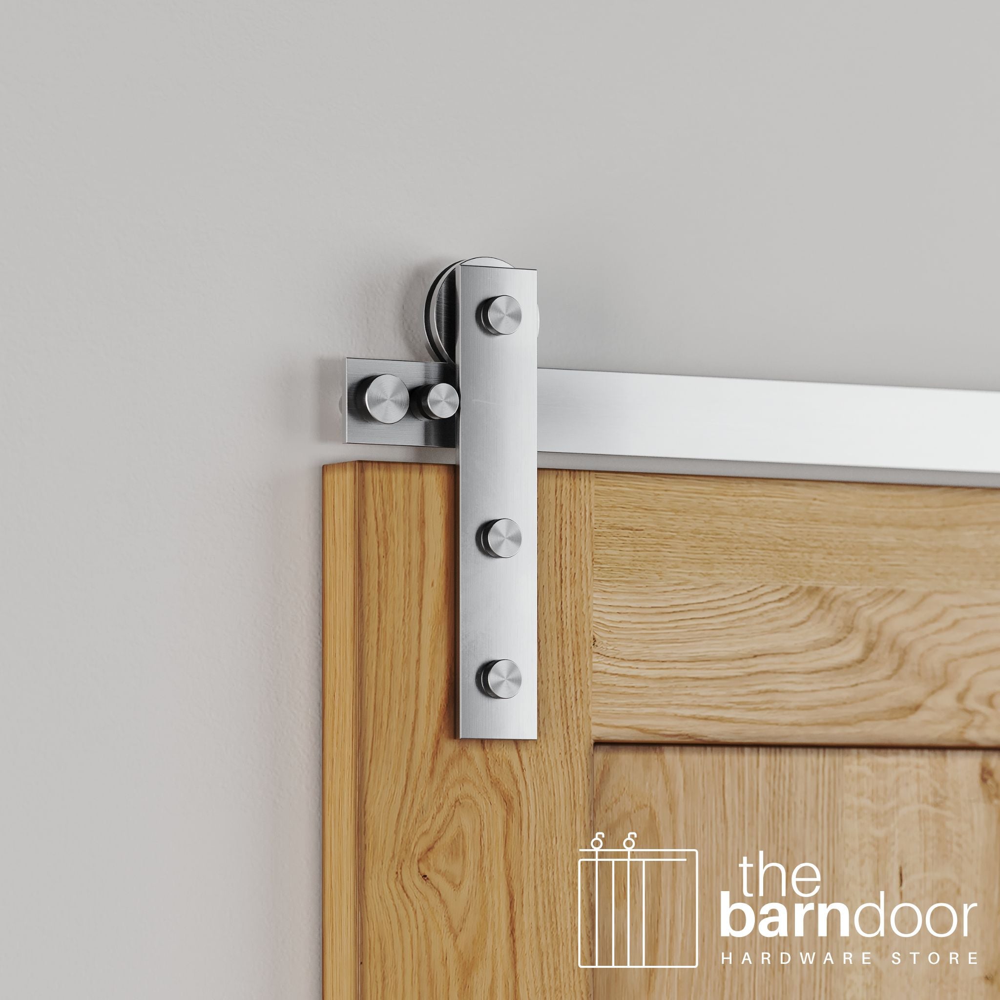 Close-up of Stainless Steel Soft-Corner Strap barn door hardware installed on a natural oak wood door, emphasizing the sleek, modern strap and brushed finish.