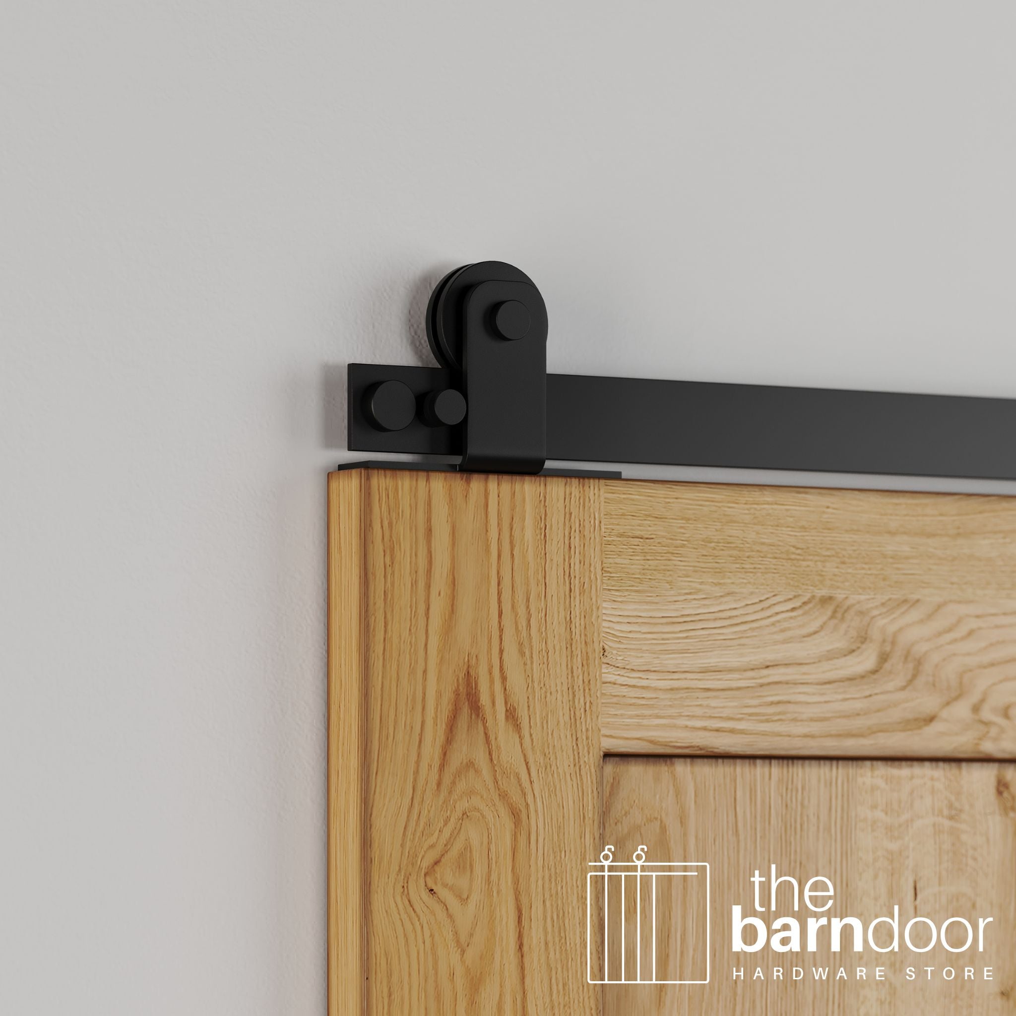 Close-up of Black Stainless Steel Straight Top Mount barn door hardware installed on the top edge of a natural oak wood door, showing the square bracket and simple roller wheel.