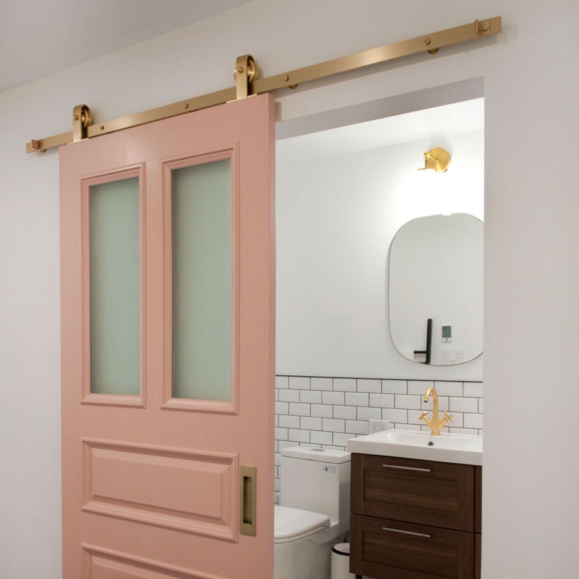 Top Mount Brass Barn Door Hardware on Pink Door