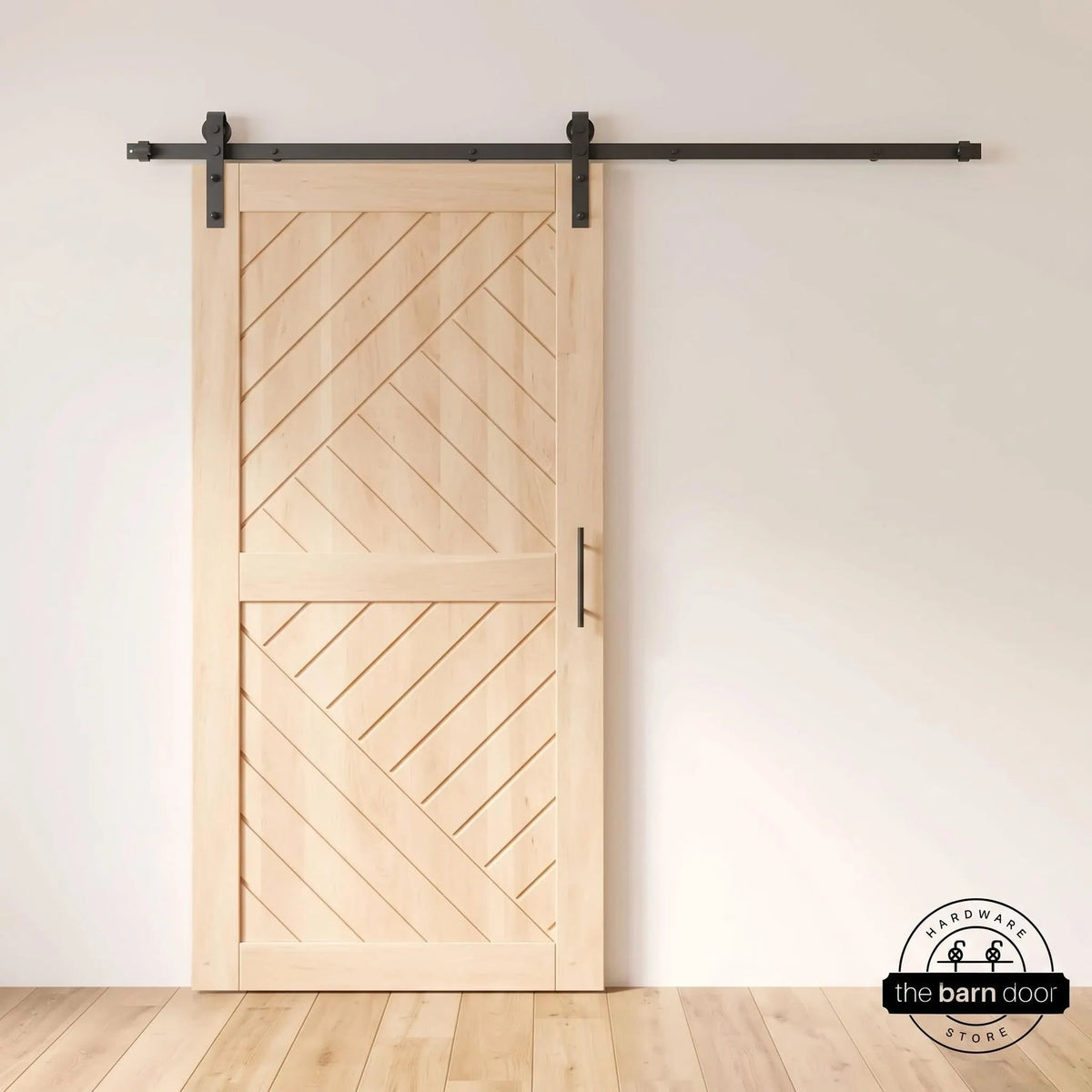 Unfinished chevron sliding barn door with matte black track, hangers, and bar pull in a white room with light oak floors