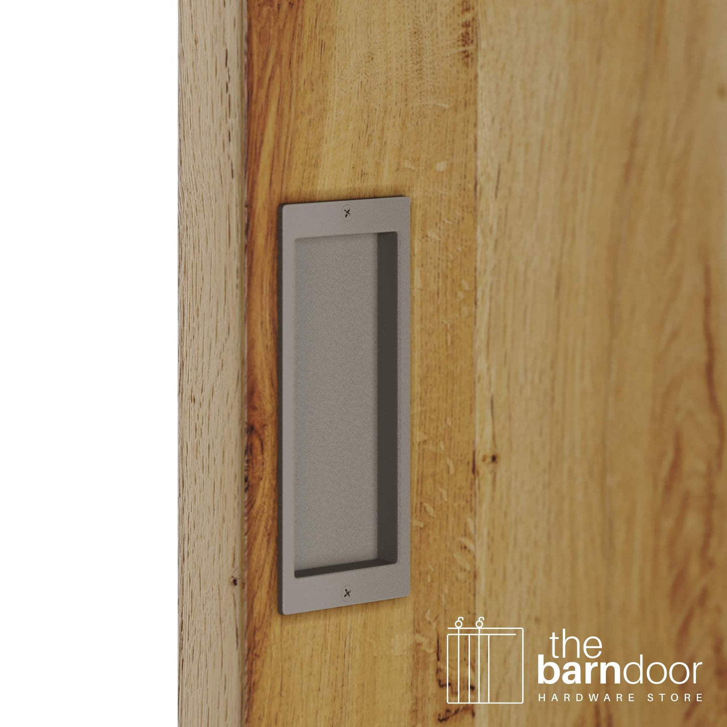 A close-up shot of a recessed rectangular flush pull handle in a white bronze finish, installed on a light brown wooden barn door.