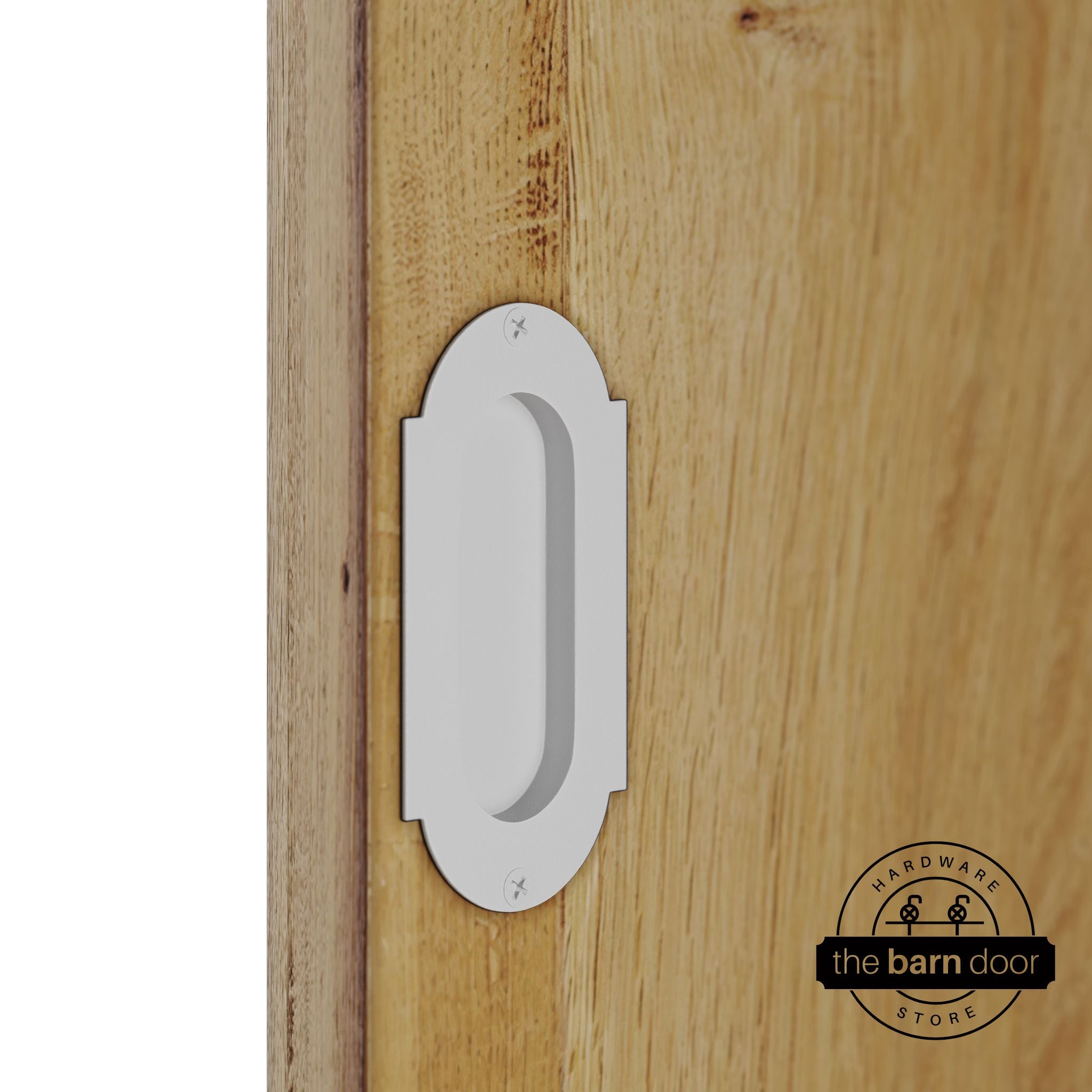 White flush pull handle with full radius wings mounted on a light oak barn door, brushed silver finish with oval recessed grip and four mounting screws