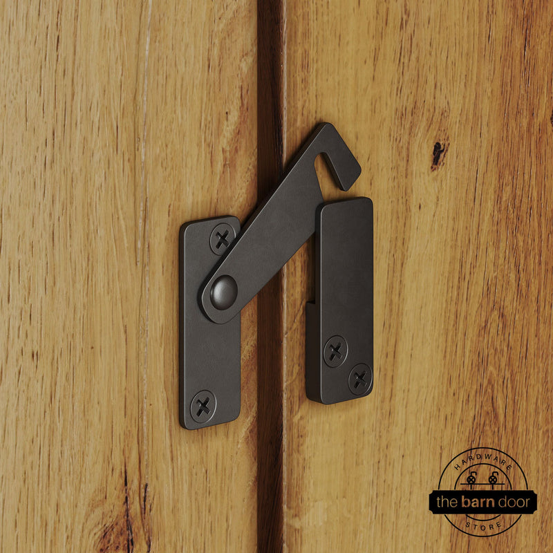 Arch bronze privacy latch for biparting barn doors, shown latched across two wood door panels