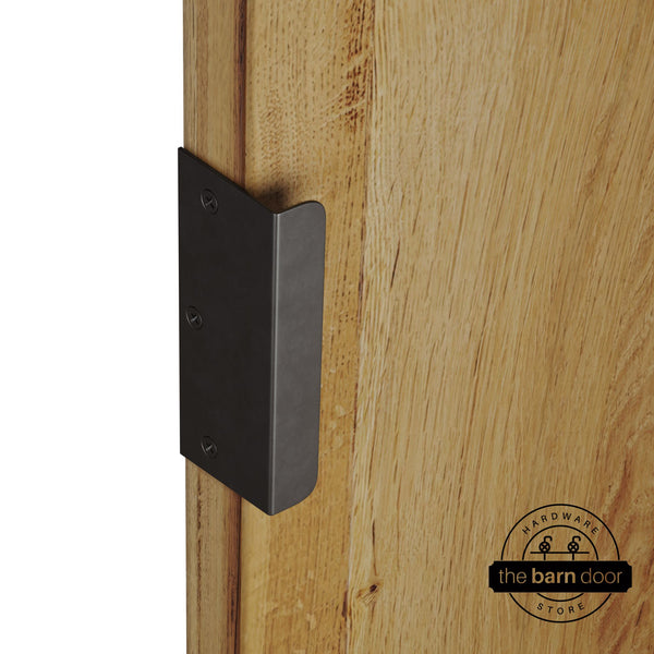 Arch bronze sliding barn door edge pull handle on natural wood door edge