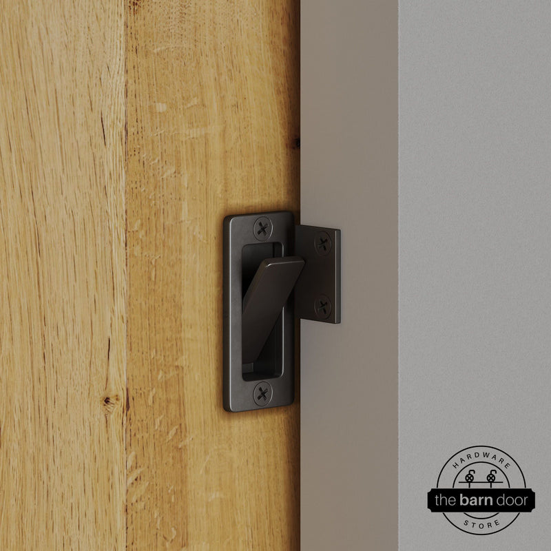 Arch bronze privacy latch installed on a sliding barn door, shown in the locked position against door frame