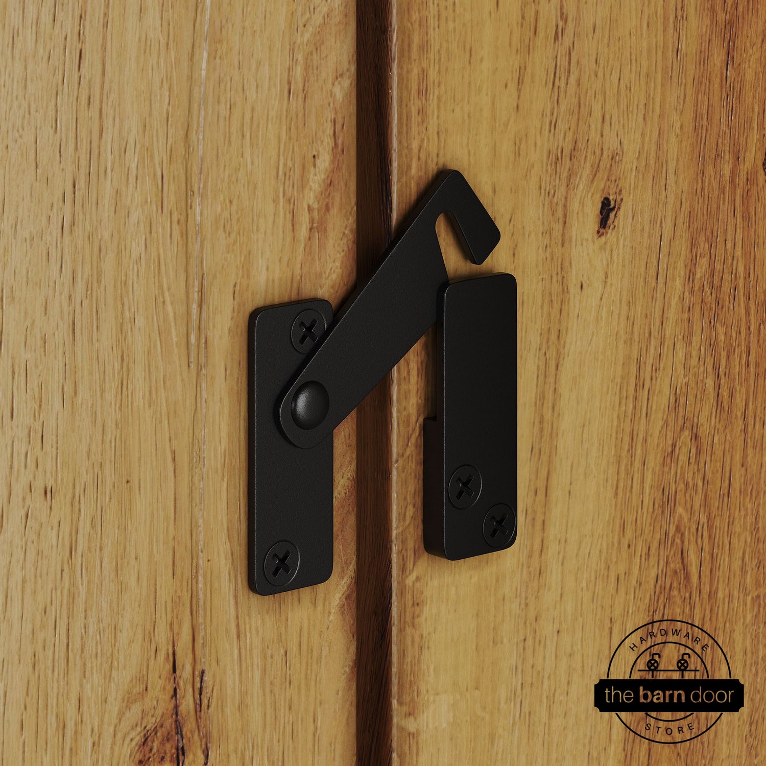 Black privacy latch for biparting barn doors, shown latched across two wood door panels