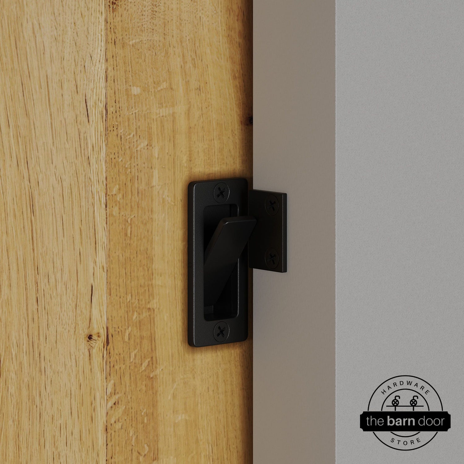 Black privacy latch installed on a sliding barn door, shown in the locked position against door frame