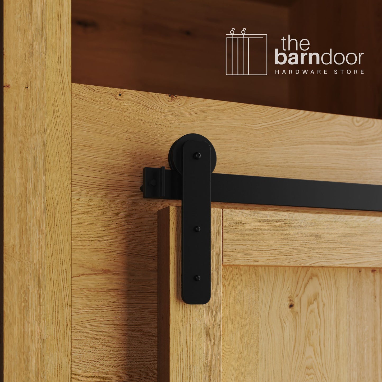 A close-up photograph of a natural oak cabinet with a sliding mini barn door, featuring a black straight-strap hanger and a black track system.