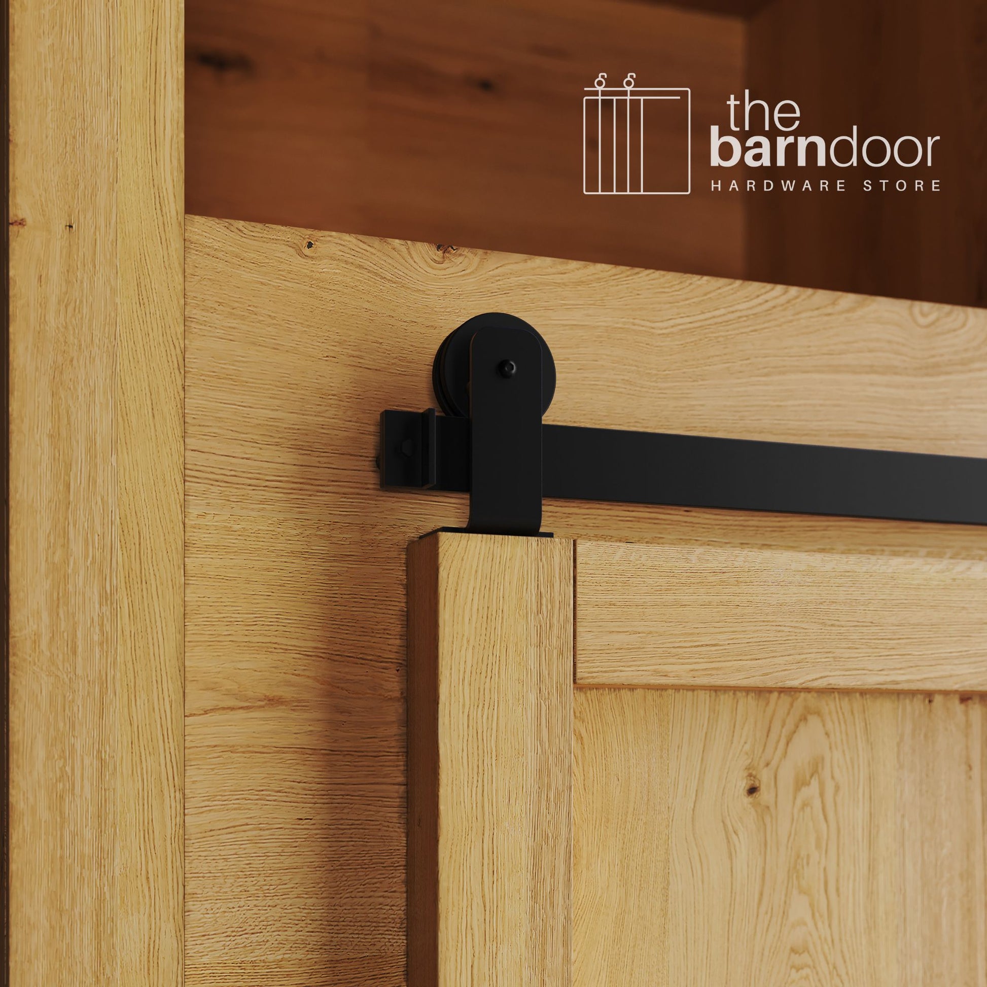A close-up photograph of a sliding mini barn door on a natural oak cabinet, featuring black top-mount straight hardware.