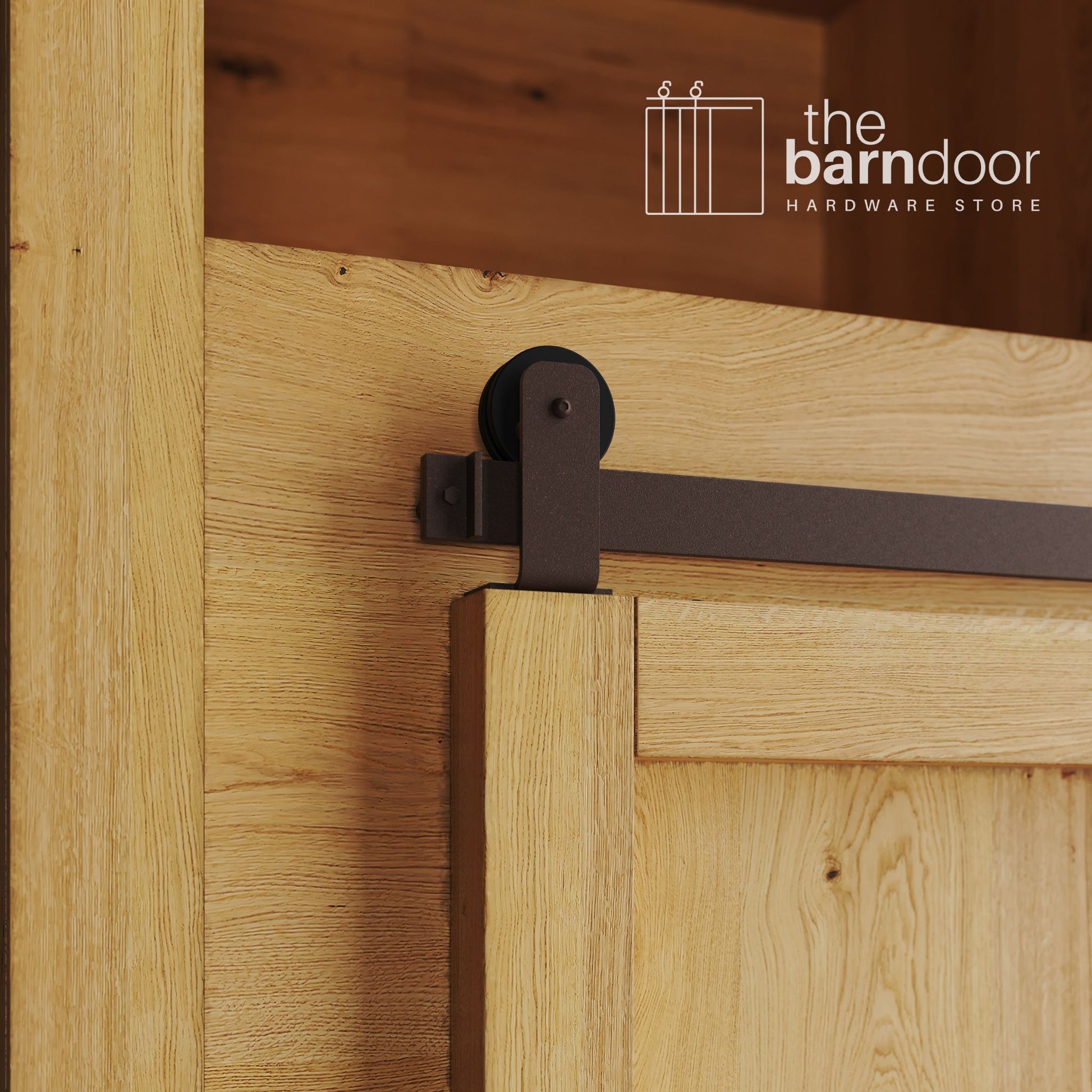 A close-up photograph of a sliding mini barn door on a natural oak cabinet, featuring bronze top-mount straight hardware.