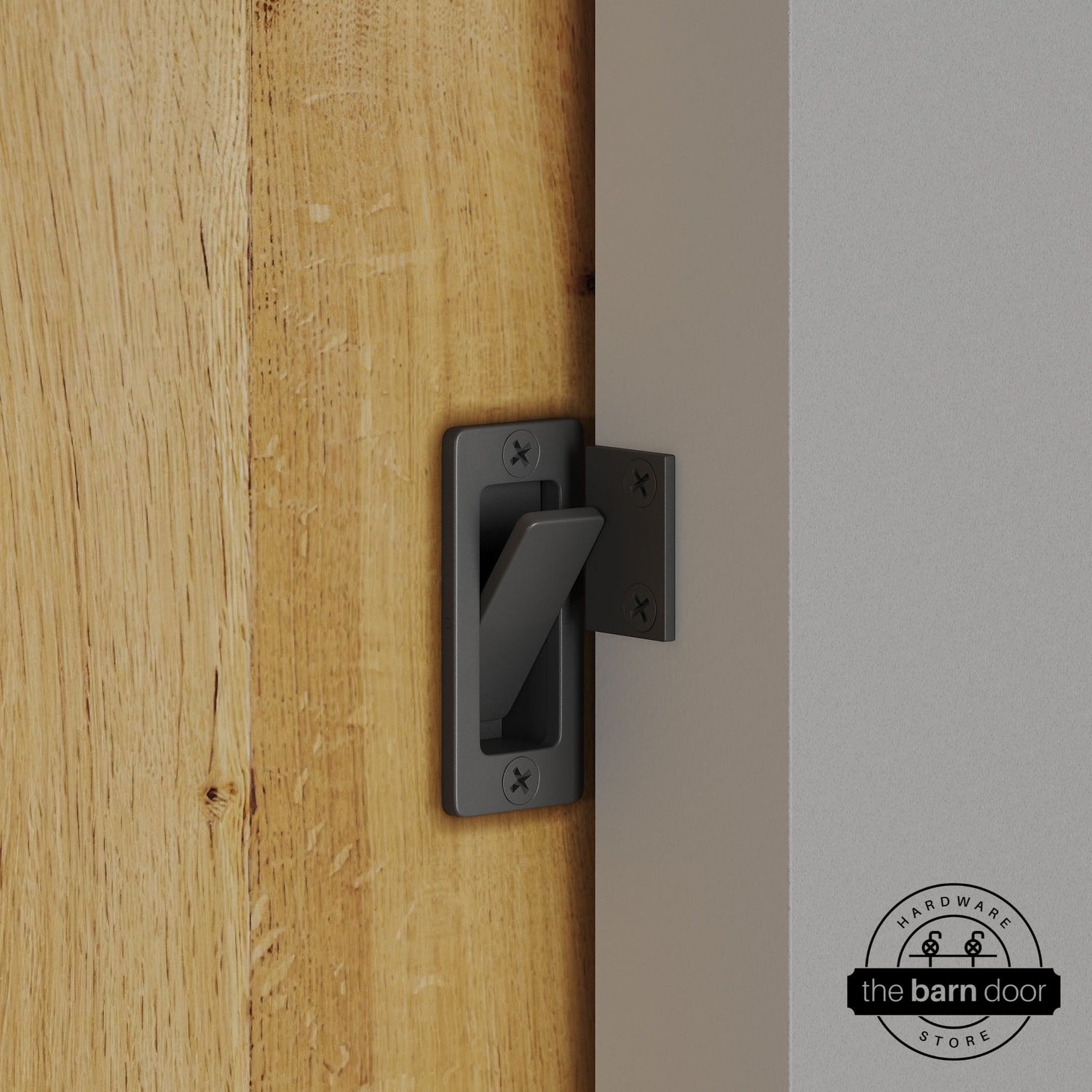 Dark gray privacy latch installed on a sliding barn door, shown in the locked position against door frame