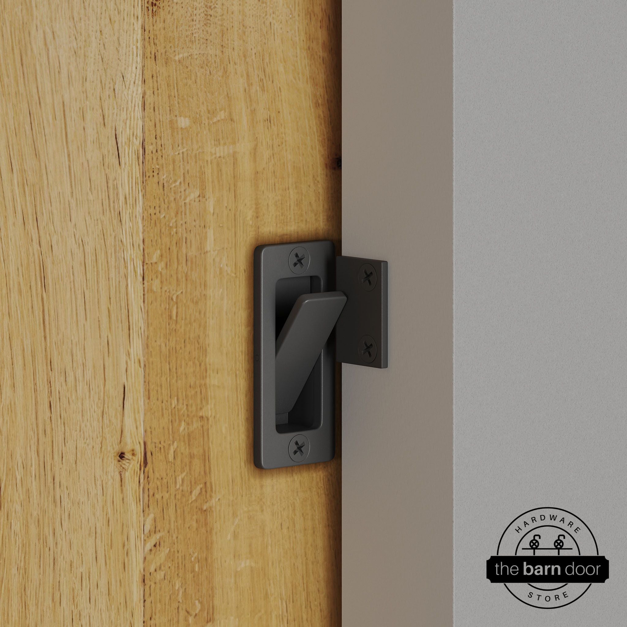 Dark gray privacy latch installed on a sliding barn door, shown in the locked position against door frame