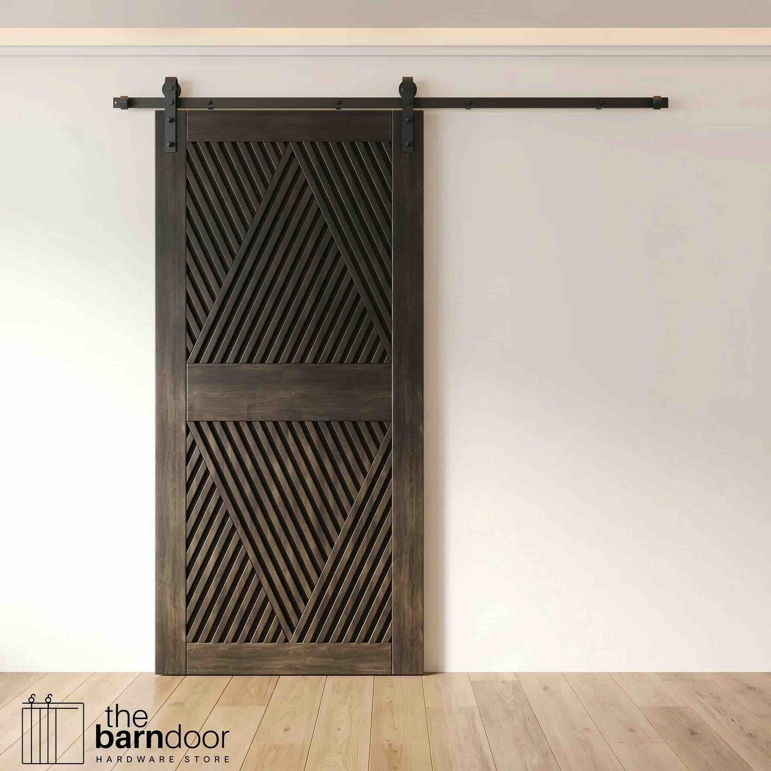 A modern ebony barn door with an intricate geometric diamond pattern installed on a black track in a contemporary living space with a fireplace.