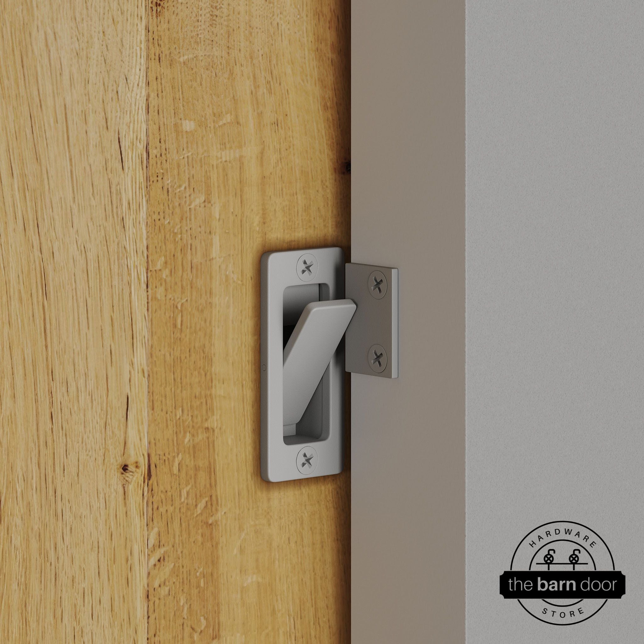 Flint gray privacy latch installed on a sliding barn door, shown in the locked position against door frame
