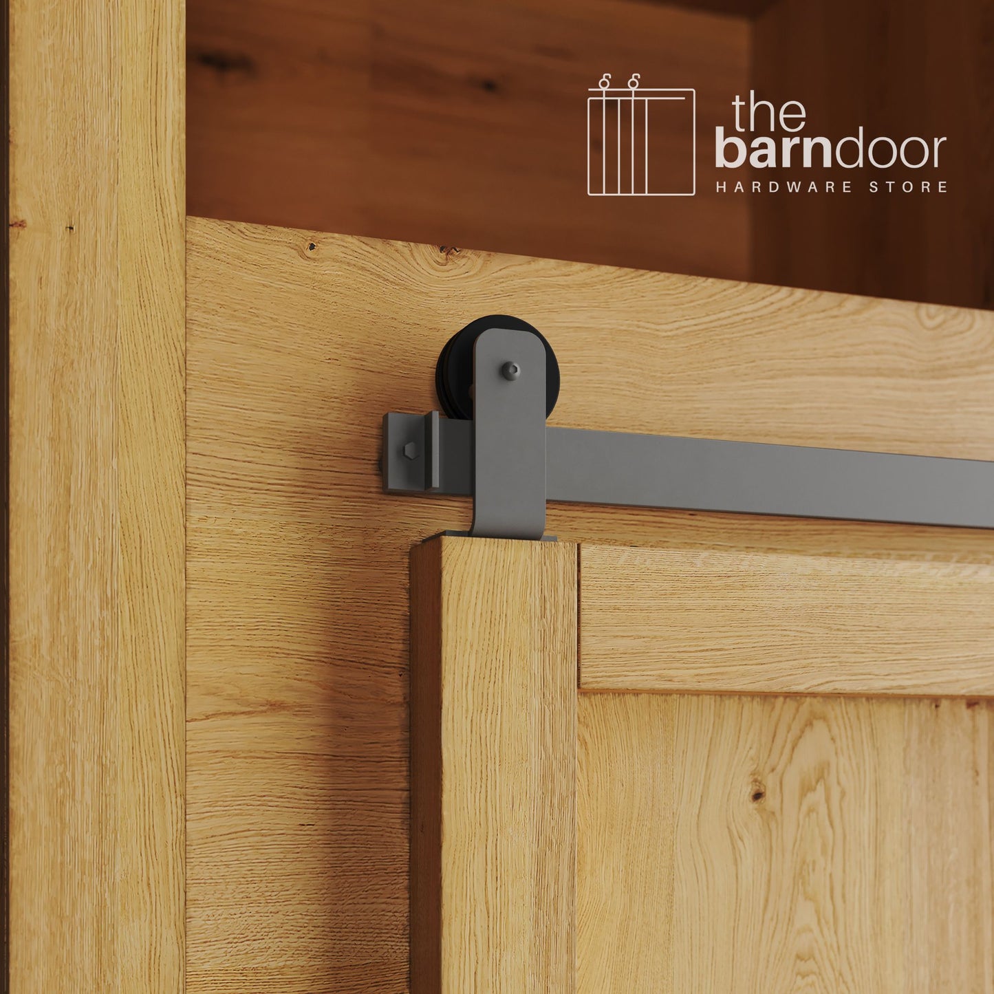 A close-up photograph of a sliding mini barn door on a natural oak cabinet, featuring flint gray top-mount straight hardware.