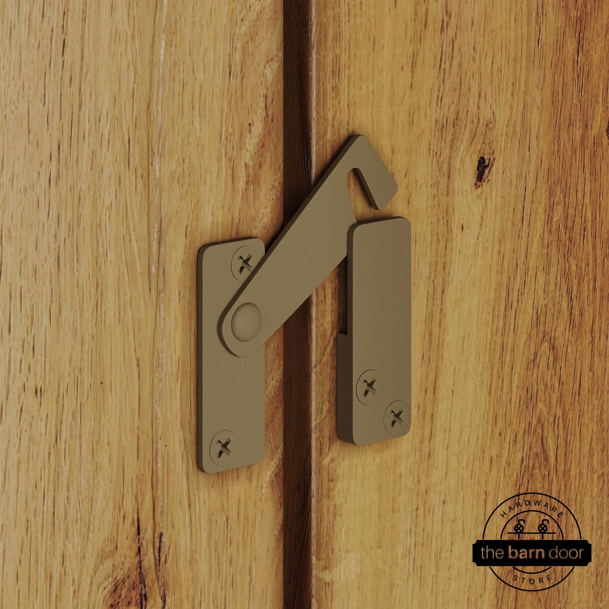 Gold privacy latch for biparting barn doors, shown latched across two wood door panels