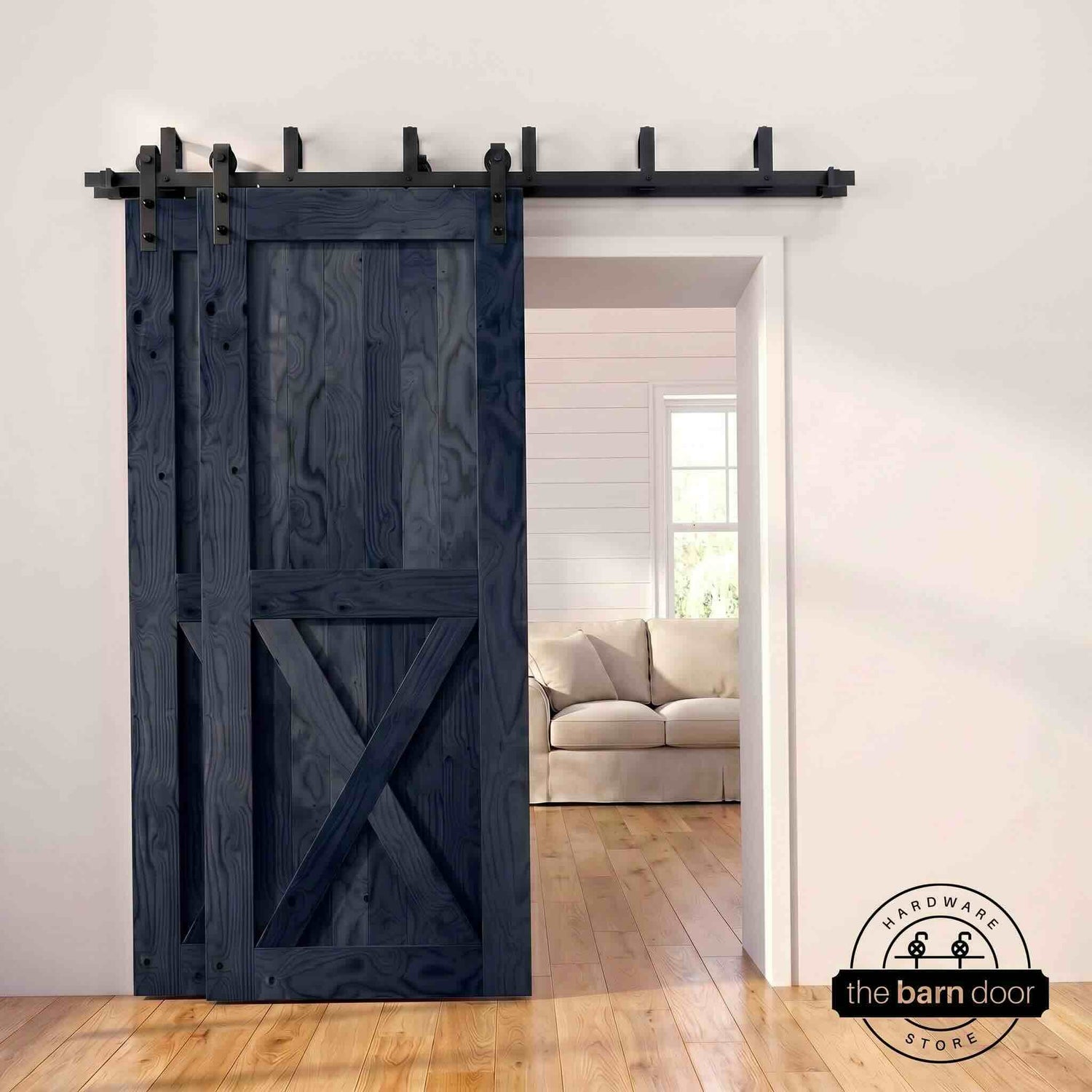 Navy pine bypass barn door with  black hardware track, mounted over living room entryway