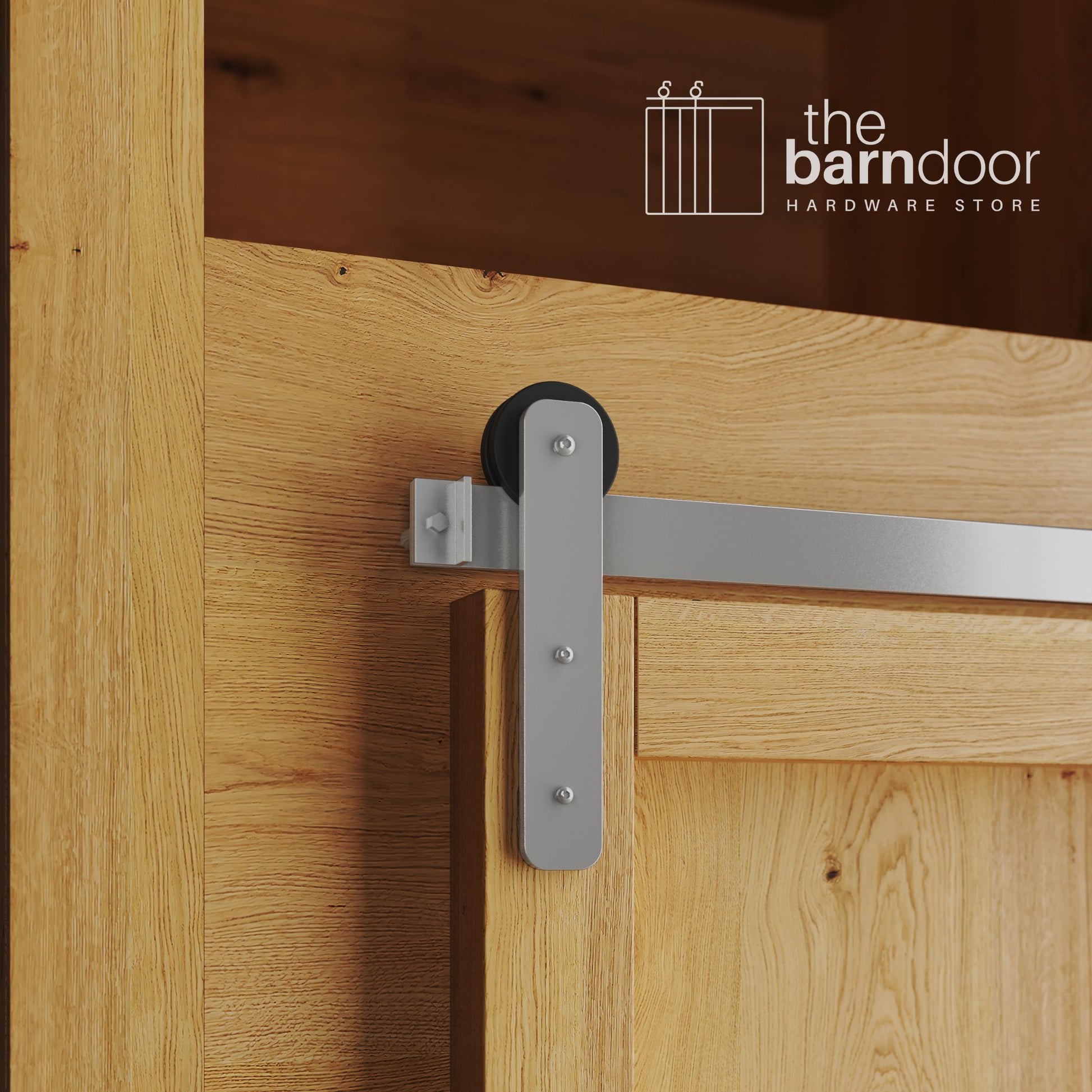 A close-up photograph of a natural oak cabinet with a sliding mini barn door, featuring a PC Chrome straight-strap hanger and a PC Chrome track system.
