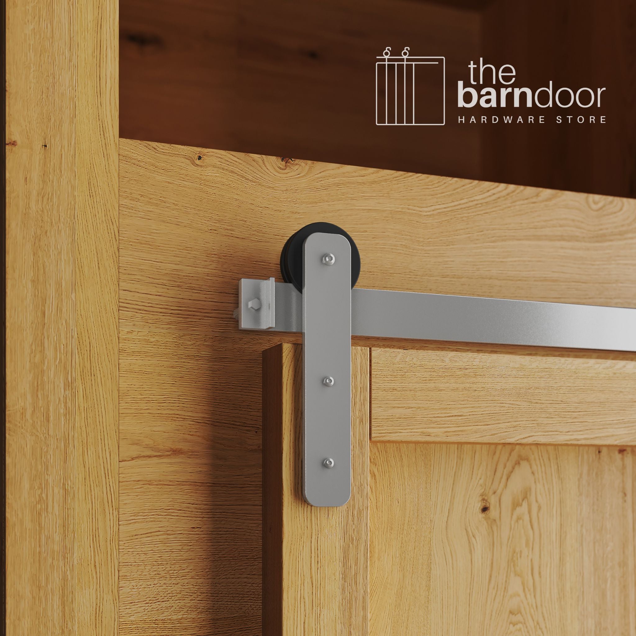 A close-up photograph of a natural oak cabinet with a sliding mini barn door, featuring a PC Chrome straight-strap hanger and a PC Chrome track system.