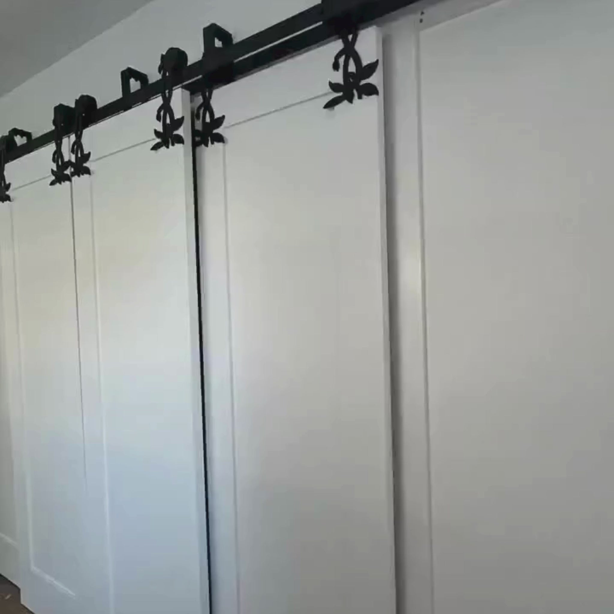 Flower double bypass barn door hardware installed on a closet