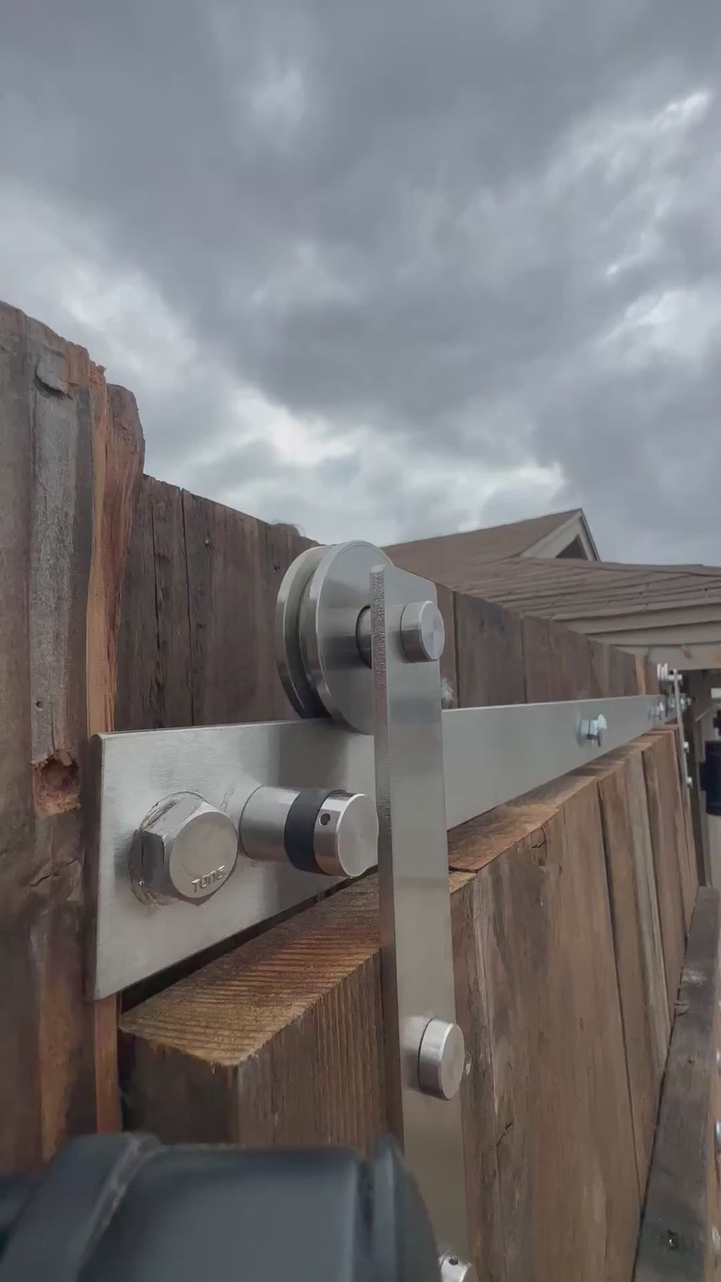 Close up of the soft corner strap stainless steel barn door hardware in an exterior application