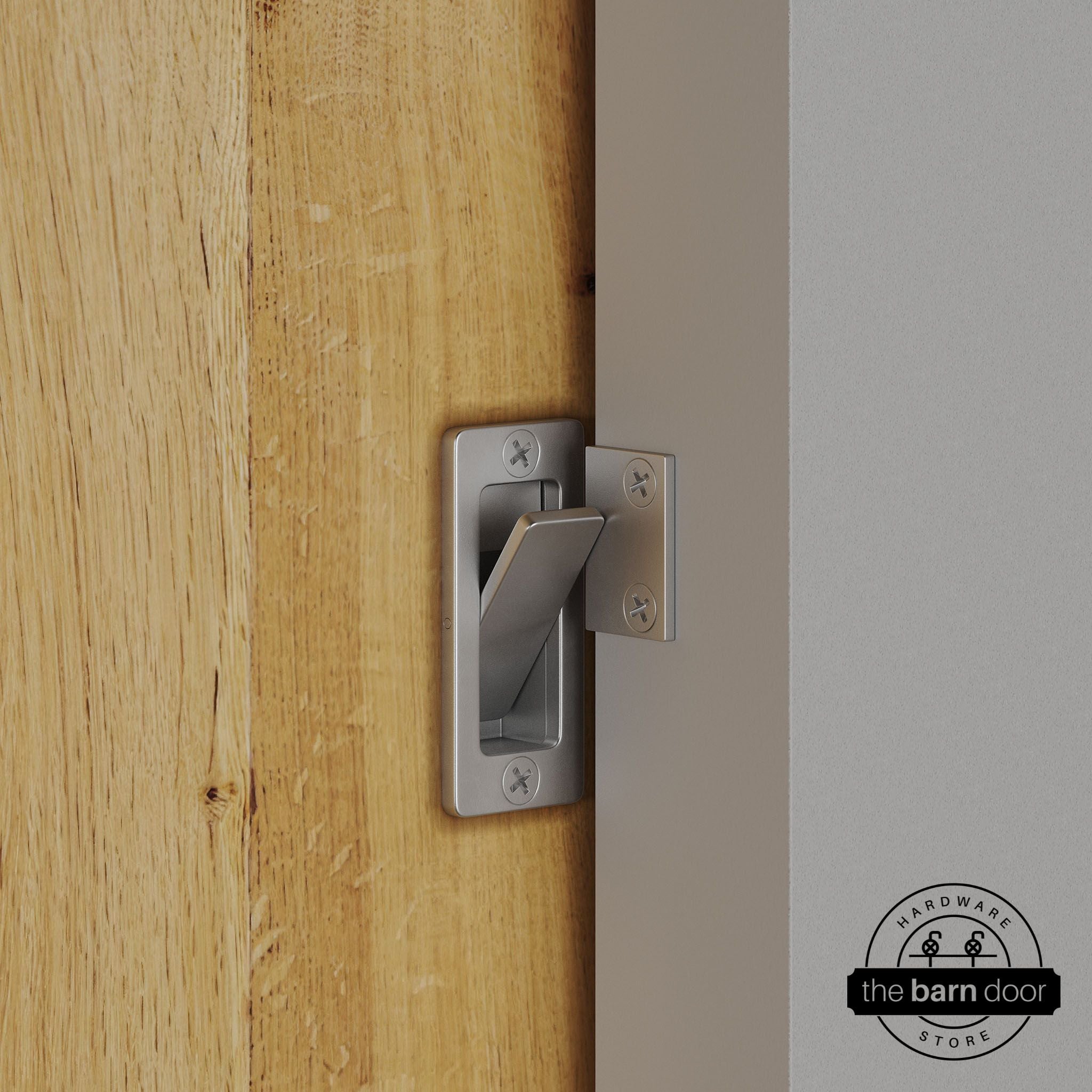 Raw steel privacy latch installed on a sliding barn door, shown in the locked position against door frame
