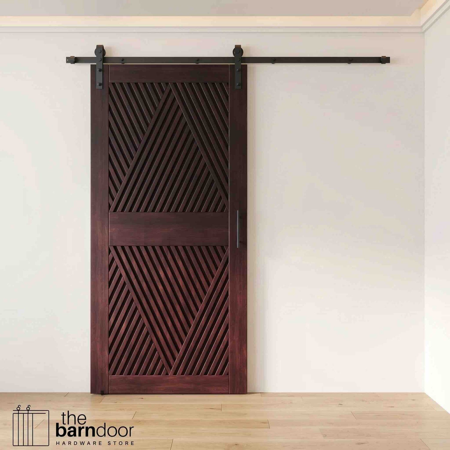 A modern red mahogany barn door with an intricate geometric diamond pattern installed on a black track in a contemporary living space with a fireplace.