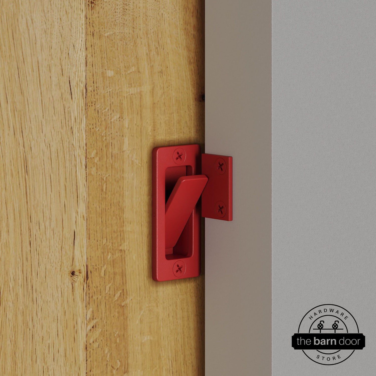 Red privacy latch installed on a sliding barn door, shown in the locked position against door frame