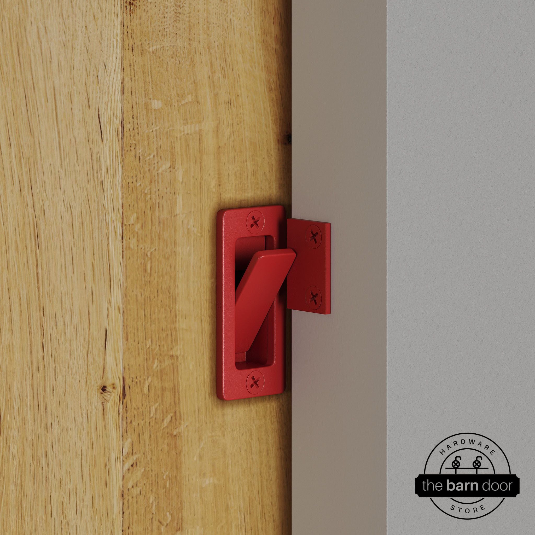 Red privacy latch installed on a sliding barn door, shown in the locked position against door frame