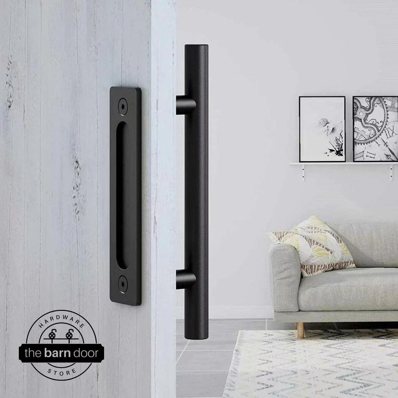 Matte black round pull and flush handle set installed on a white wood sliding barn door