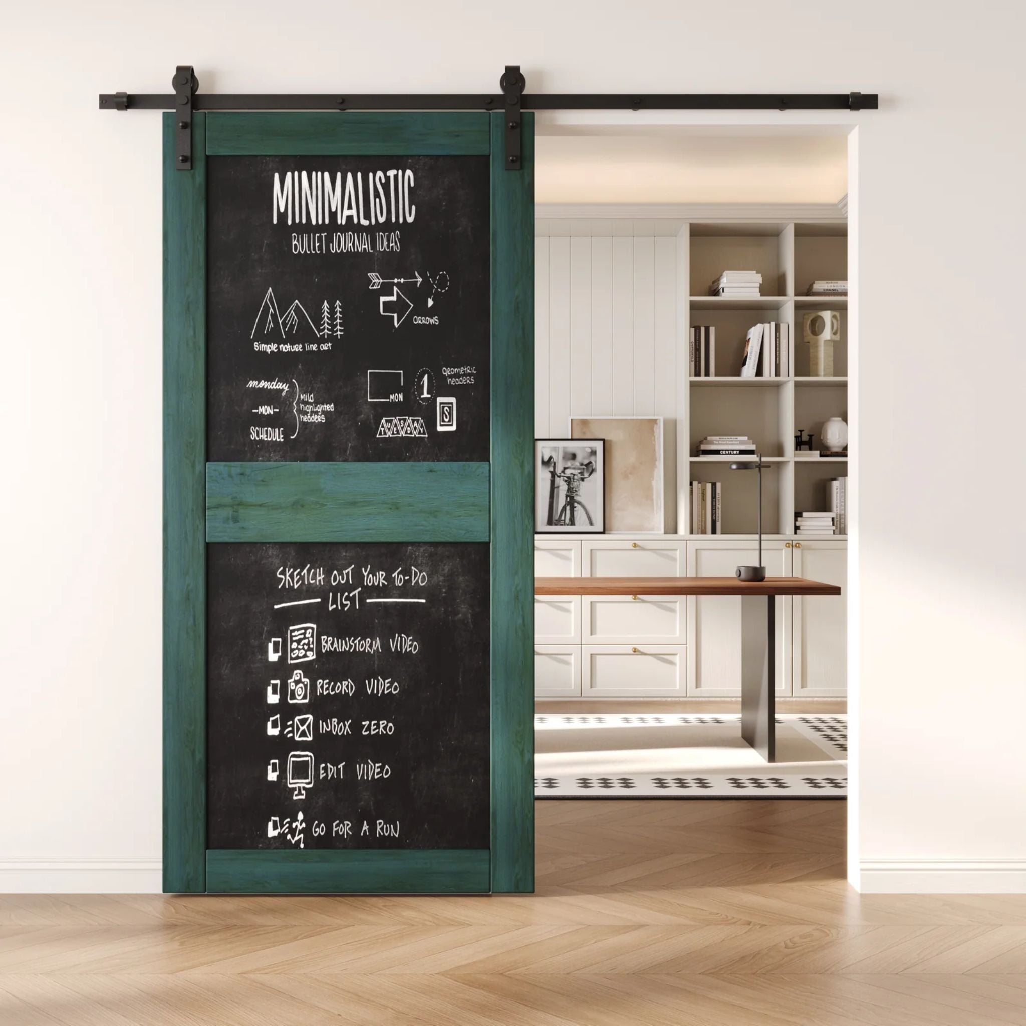 A royal pine two-panel chalkboard barn door mounted on a sleek black sliding track, shown partially open to reveal a modern home office with built-in white shelving.