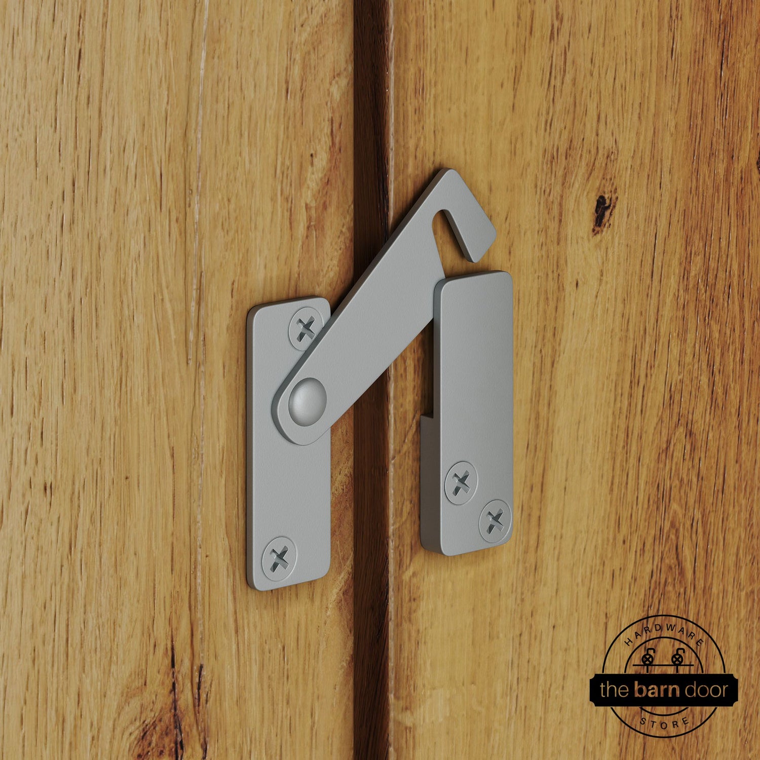 Silver metallic privacy latch for biparting barn doors, shown latched across two wood door panels