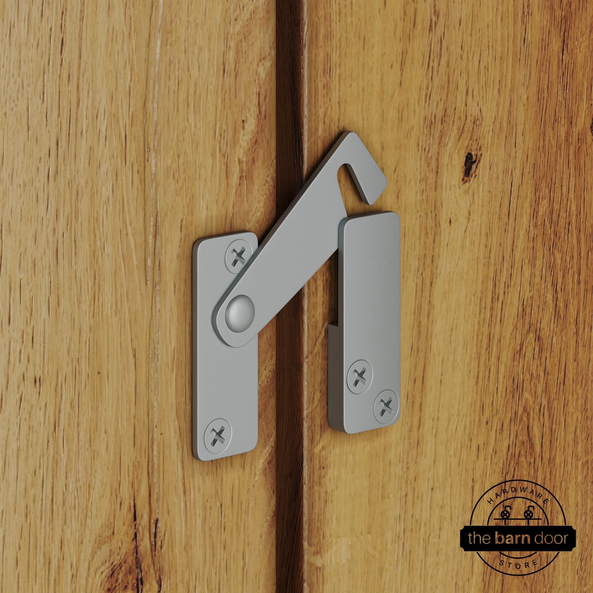 Silver metallic privacy latch for biparting barn doors, shown latched across two wood door panels