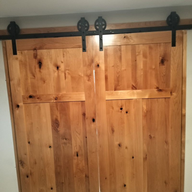 Customer image of biparting spoke wheel barn door hardware on their installed doors
