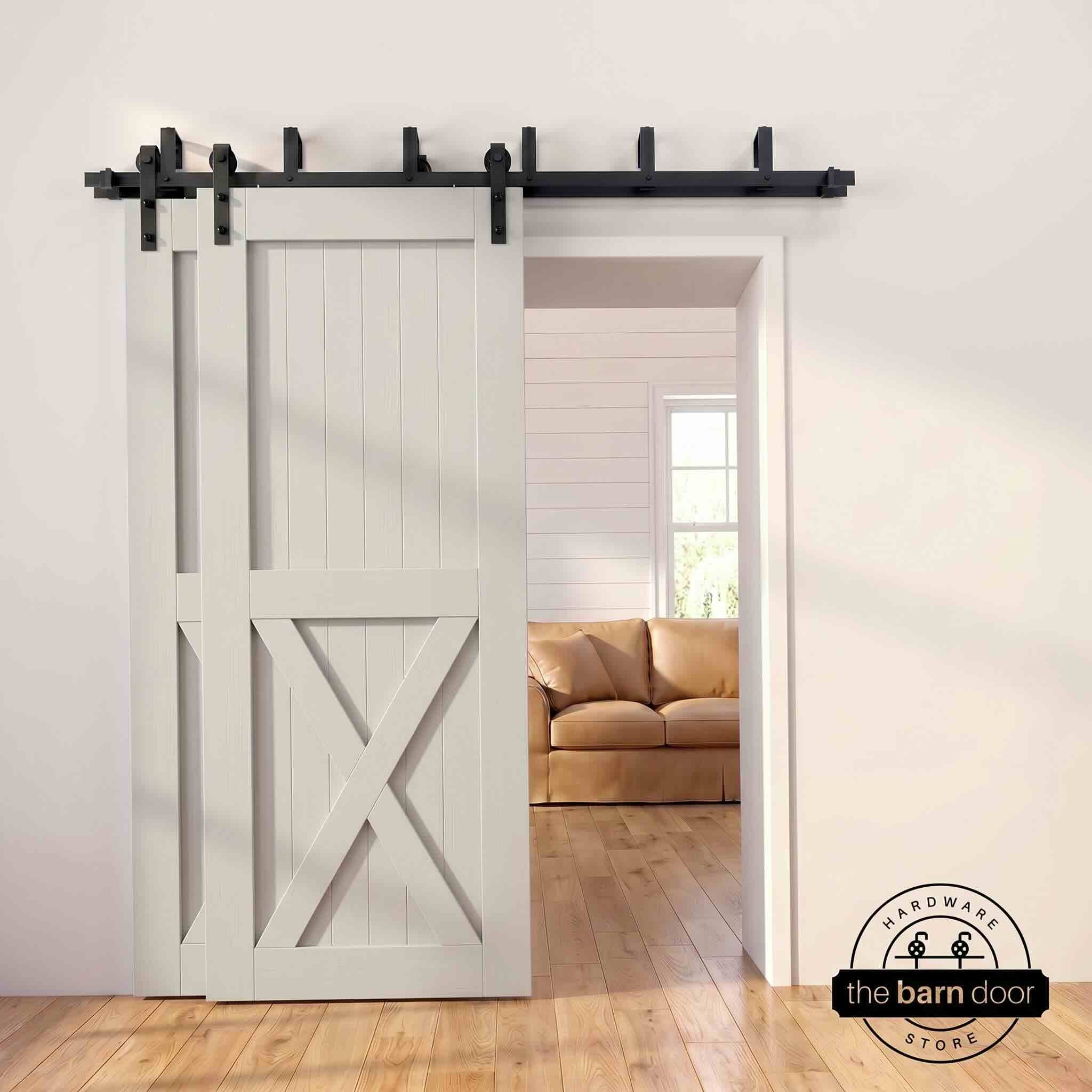 Tinsmith gray pine bypass barn door with  black hardware track, mounted over living room entryway