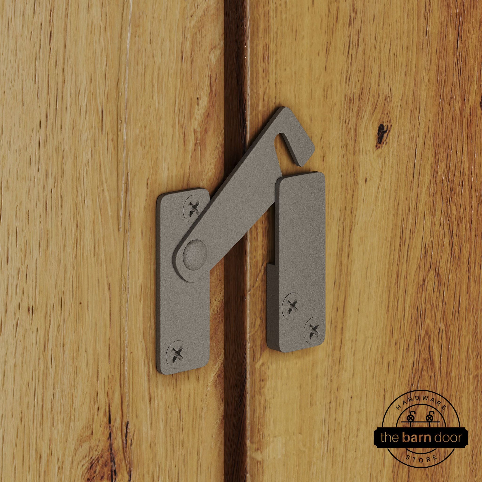 White bronze privacy latch for biparting barn doors, shown latched across two wood door panels