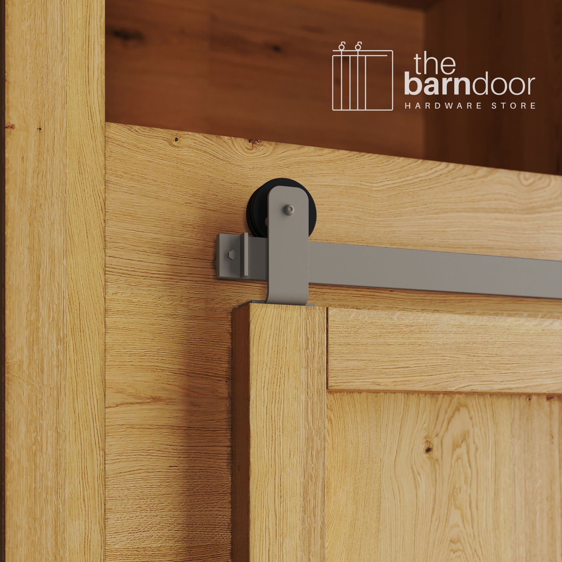 A close-up photograph of a sliding mini barn door on a natural oak cabinet, featuring white bronze top-mount straight hardware.